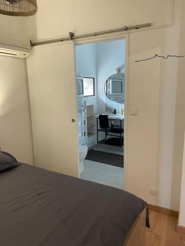 une chambre avec un lit et une salle de bain avec un lavabo dans l'établissement Pointe Rouge: Petit cocon entre mer et colline, à Marseille