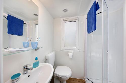 een witte badkamer met een toilet en een wastafel bij Albatross Mobile Homes on Camping Eden in San Felice del Benaco