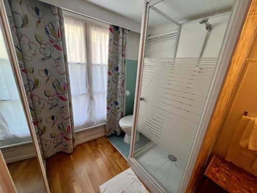 a bathroom with a toilet and a glass shower at Hôtel Tiquetonne in Paris