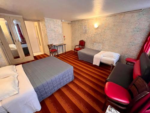 Cette chambre d'hôtel comprend deux lits, une table et des chaises. dans l'établissement Hôtel Tiquetonne, à Paris