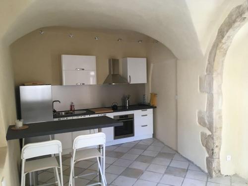 - une cuisine avec un comptoir et deux tabourets dans l'établissement Gîte largentiere, à Largentière