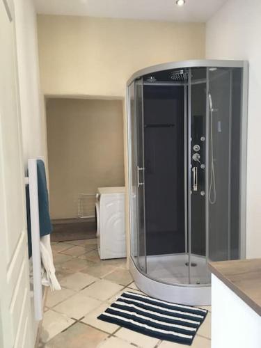 une salle de bain avec une douche en verre dans une chambre dans l'établissement Gîte largentiere, à Largentière