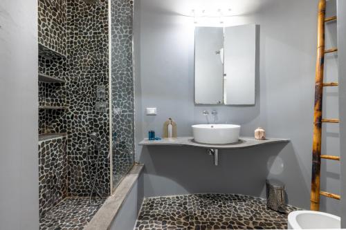 a bathroom with a sink and a shower with a mirror at Modern apartment in Campo de Fiori in Rome