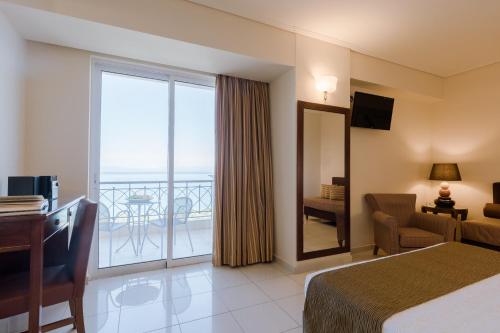 a hotel room with a bed and a balcony at Akti Taygetos - Conference Resort in Kalamata