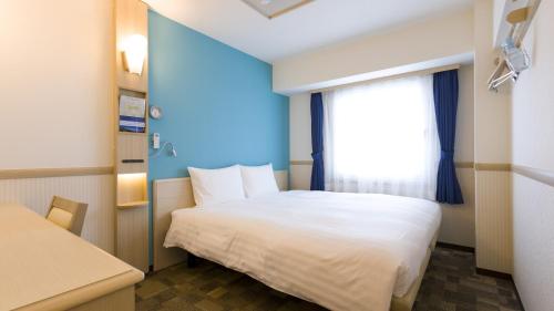 a bedroom with a white bed and a window at Toyoko Inn Ebina eki Higashi guchi in Ebina