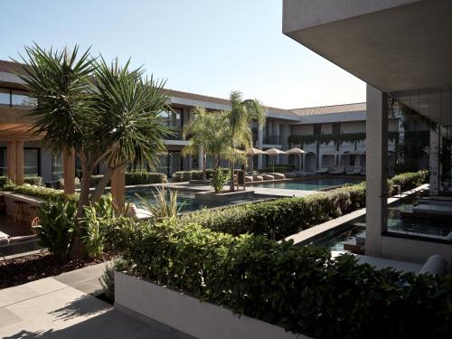 een extern uitzicht op een gebouw met een zwembad en palmbomen bij Contessina Suites & Spa - Adults Only in Tsilivi
