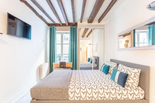 una camera con un grande letto e una TV di Ternes Cozy Studio a Parigi