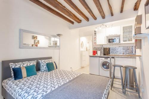 une chambre avec un lit avec des oreillers bleus et blancs dans l'établissement Ternes Cozy Studio, à Paris