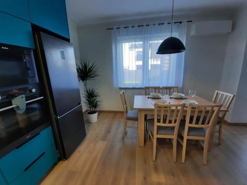 a kitchen and dining room with a table and chairs at Chabrowa Apartamenty 1 in Milicz