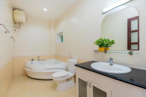 a bathroom with a toilet and a sink and a mirror at Cát Tường Villa gần biển in Vung Tau