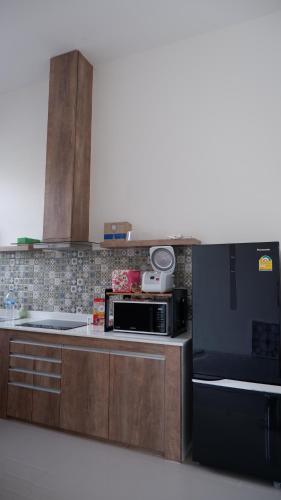 a kitchen with a microwave oven and a stove at The Midst by The M - Nakhon Nayok TMD4 in Ban Som Phung Haeng (1)