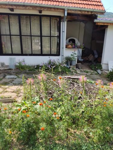 a garden in front of a house with flowers at къща за гости Хайк in Beli Osŭm