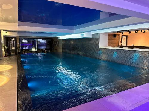 a swimming pool in a hotel with blue lighting at Apartman Planinski raj in Kopaonik