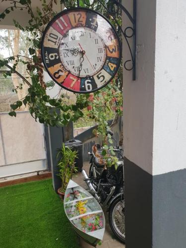 a clock hanging on the side of a building at Homestay by the Tea Garden Dibrugarh in Dibrugarh