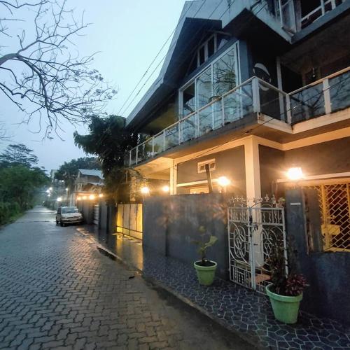 a house with a car parked in front of it at Homestay by the Tea Garden Dibrugarh in Dibrugarh