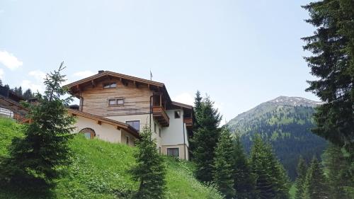 a house on the side of a hill with trees at Haus Martina in Hochfügen - ohne Verpflegung in Hochfugen