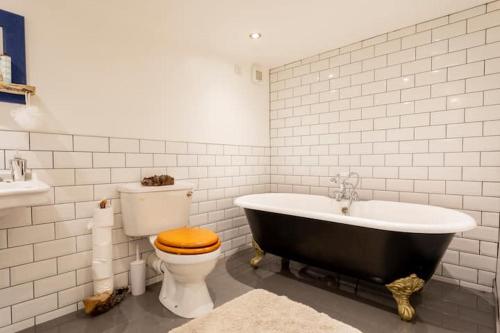 a bathroom with a black tub and a toilet at The Byre (Unusual and Different). in Dromore