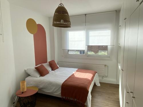een kleine slaapkamer met een bed en een raam bij Appartement situé en centre ville super lumineux in Duinkerke