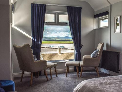 Zimmer mit einem Fenster mit Stühlen und einem Bett in der Unterkunft Teds Place in Arnside