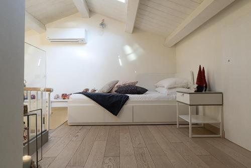 1 dormitorio con cama blanca y suelo de madera en Timone 31, en Civitanova Marche
