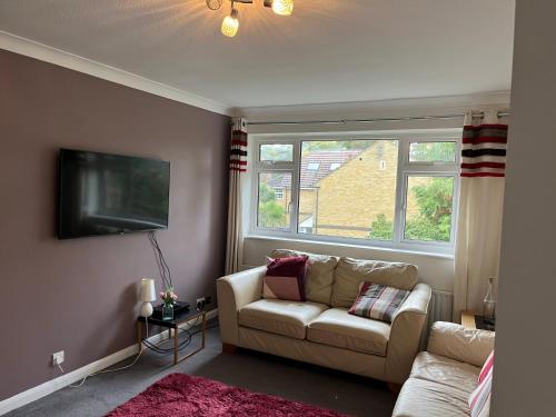 a living room with a couch and a tv at A Home from Home in Ascot