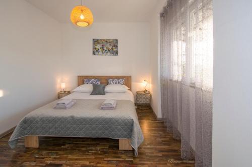a bedroom with a bed and a large window at Apartman Fuma in Rovinj