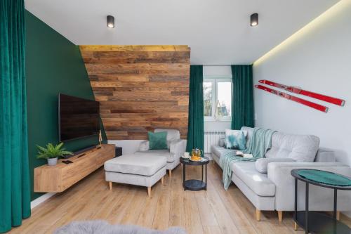 uma sala de estar com um sofá e uma televisão em Apartament Salamandra Giewont View by Renters Prestige em Zakopane