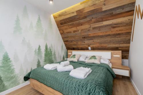 um quarto com uma cama verde e toalhas em Apartament Salamandra Giewont View by Renters Prestige em Zakopane