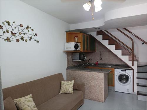 ein Wohnzimmer mit einer Couch und einer Treppe in der Unterkunft Apartamento situado en Maspalomas in Las Palmas de Gran Canaria