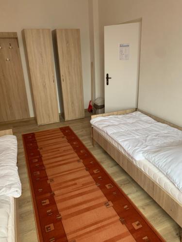 a room with two beds and a door in it at Hostel SOS Moldava in Moldava nad Bodvou