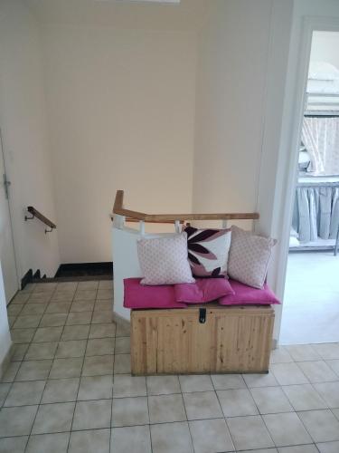 1 cama con almohadas encima de una caja de madera en lit en dortoir toulouse minimes, en Toulouse