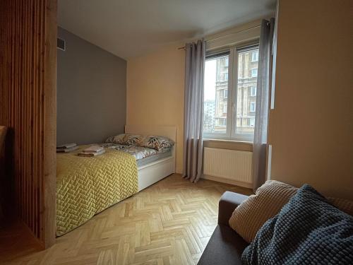 um pequeno quarto com uma cama e uma janela em Bonifraterska 15 Studio - Old Town Apartment em Varsóvia