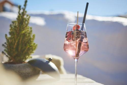 a wine glass with cherries in it next to a plant at Bauernhof Hotel Oberschwarzach in Saalbach Hinterglemm