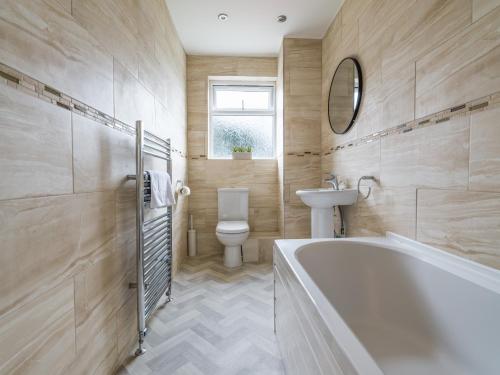 a bathroom with a tub and a toilet and a sink at Charming 3-Bed House in Newcastle upon Tyne in Newcastle upon Tyne