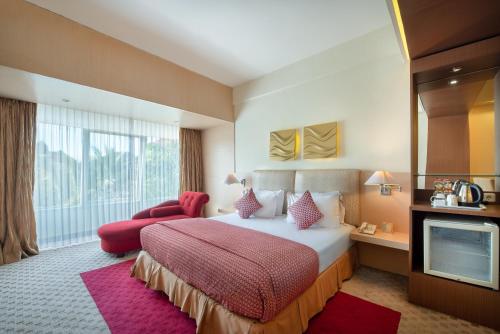 Habitación de hotel con cama y TV en Lux Tychi Hotel, en Malang