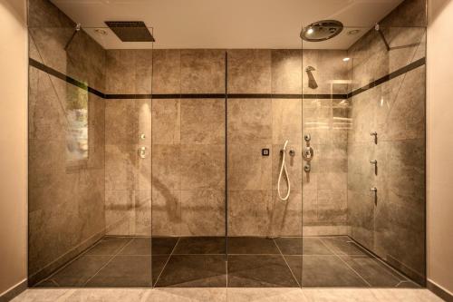 a bathroom with a shower with a glass door at Luxury Chalet Plazola in Selva di Val Gardena
