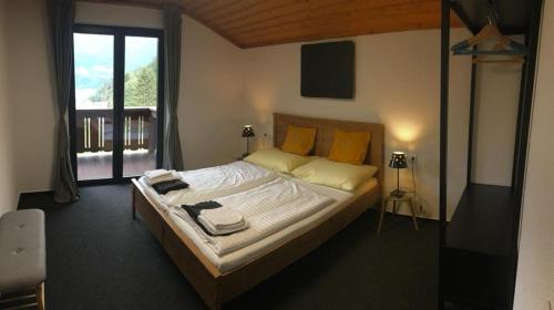 Schlafzimmer mit einem Bett mit weißer Bettwäsche und gelben Kissen in der Unterkunft Landhaus Marlies Apartments in Zell am See
