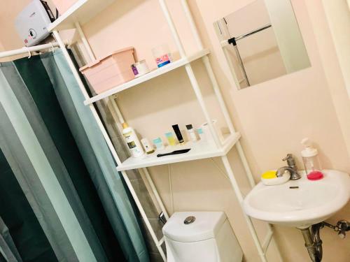 y baño con ducha, aseo y lavamanos. en Amaia Steps Bicutan with Netflix and DisneyPlus - 1BR, en Manila