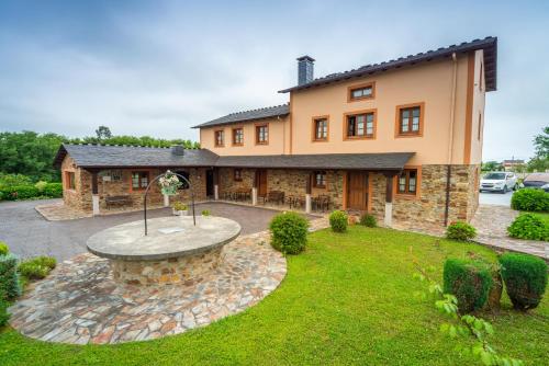 a large house with a fountain in the yard at Apartamentos Navalin in Tapia de Casariego