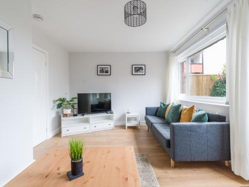 a living room with a couch and a tv at Howick House-Sleeps 5-Pet friendly-Parking-Garden in Newcastle upon Tyne