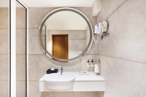 y baño con lavabo blanco y espejo. en Keys Select by Lemon Tree Hotels, Gandhi Ashram, Ahmedabad en Ahmedabad
