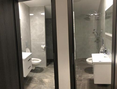y baño con 2 lavabos, aseo y ducha. en Landhaus Marlies Apartments, en Zell am See