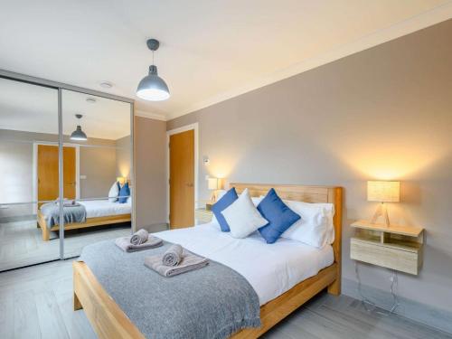a bedroom with a large bed and a mirror at Westertonhill Holiday Lodges - Hot Tub Hire Available in Balloch