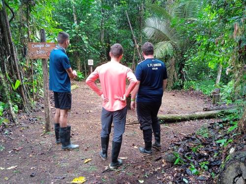 three men walking on a trail in the jungle at Cabañas eco lógicas mu'ü in Loreto Mocagua