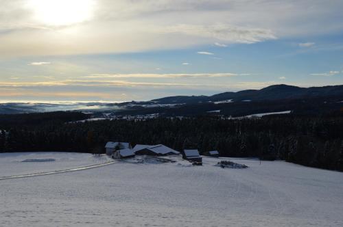 a view of a snowy mountain with the sun in the sky at Pircherhof - Adults Only am Biobauernhof in Pöllau
