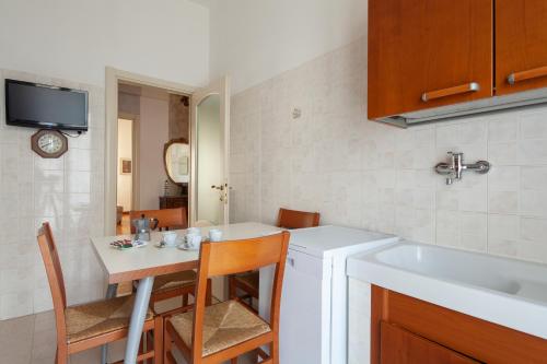 a small kitchen with a table and a sink and a table and chairs at La Spezia Holidays in La Spezia