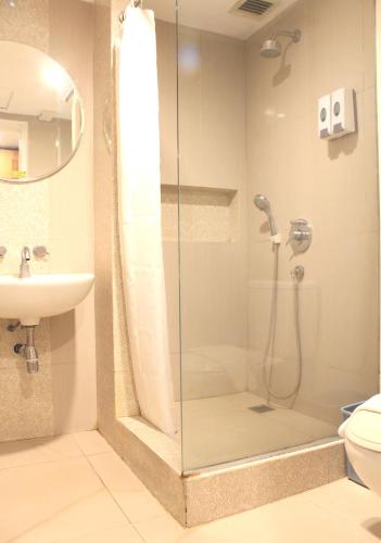 a bathroom with a shower and a sink at Lux Tychi Hotel in Malang