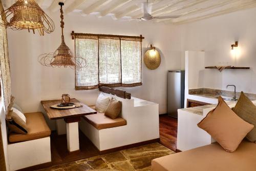 a living room with a table and a kitchen at Antares Villa in Kiwengwa