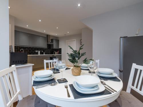 a kitchen and dining room with a white table and chairs at Charming 3-Bed House in Newcastle upon Tyne in Newcastle upon Tyne