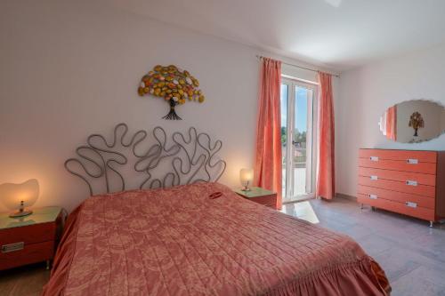 a bedroom with a bed with a red bedspread at Villa Rosanna in Capoterra